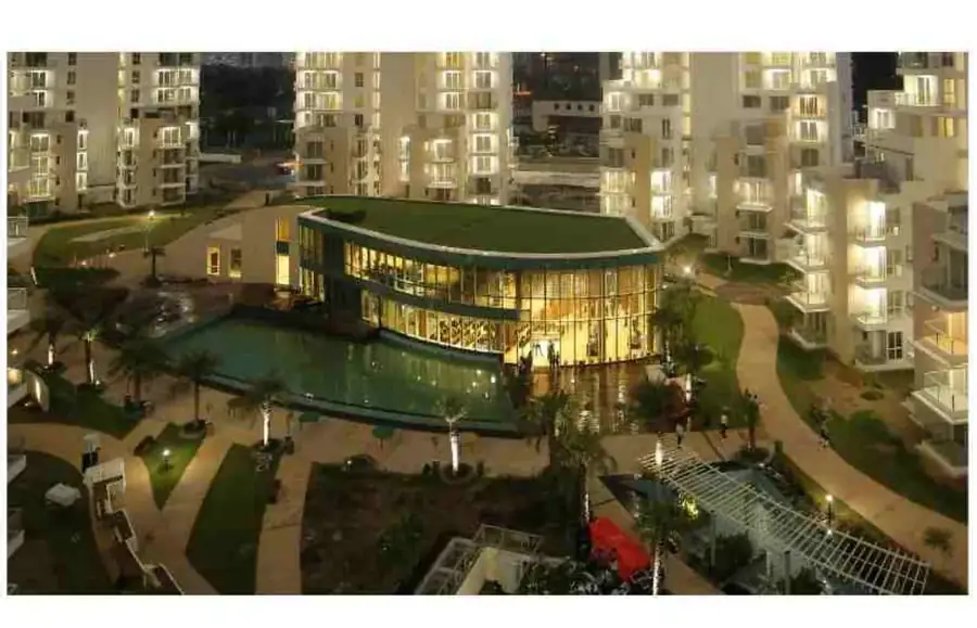 Club Sands clubhouse at M3M Merlin illuminated at night beside the pool